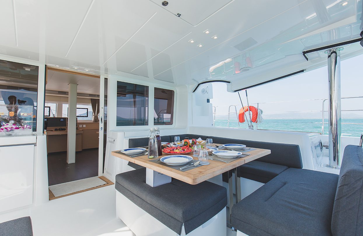 The open plan layout of Blue Moon is lively with a dining area, lounge seating, TV entertainment and galley, Photo - Wan Tse, Simpson Yacht Charter